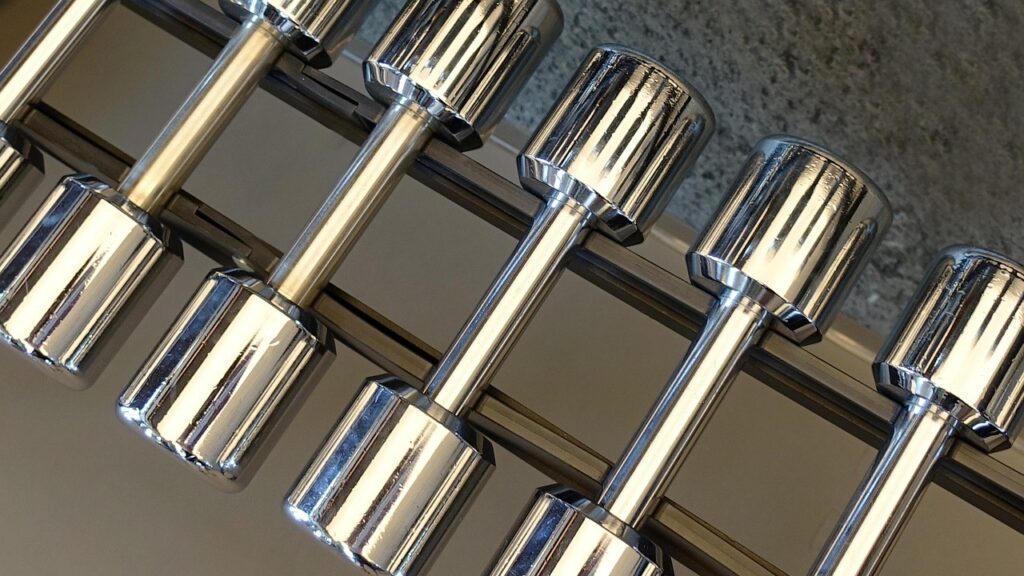 Chrome dumbbells op een rek, klaar voor gebruik in een compacte home gym