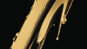 Gouden verfstrook op een zwarte achtergrond met glanzende textuur die een luxe uitstraling versterkt.