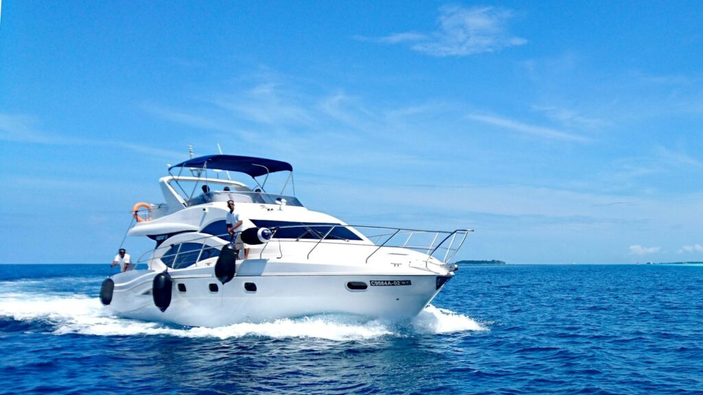 Wit jacht op volle snelheid op open zee onder een heldere blauwe lucht, symbool voor goed jacht onderhouden