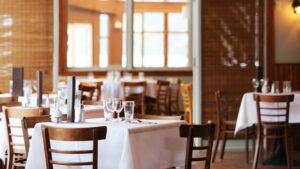 Restaurantinterieur met houten stoelen en witgedekte tafels, passend bij luxe halal gastronomie.