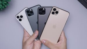 Vier luxe telefoons in verschillende kleuren met glazen behuizing en drievoudige camera's, vastgehouden in één hand